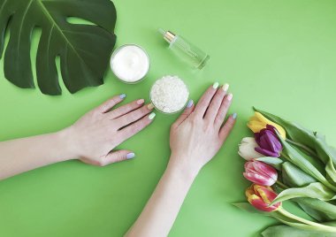 eller manikür, krem, Lale çiçek yeşil bir arka plan üzerinde