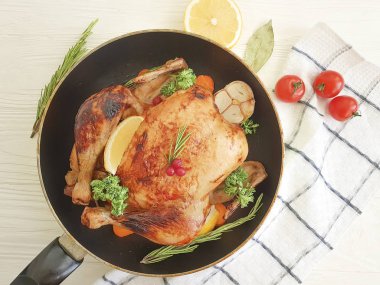 Tüm kızarmış tavuk, domates, limon beyaz bir arka plan üzerinde