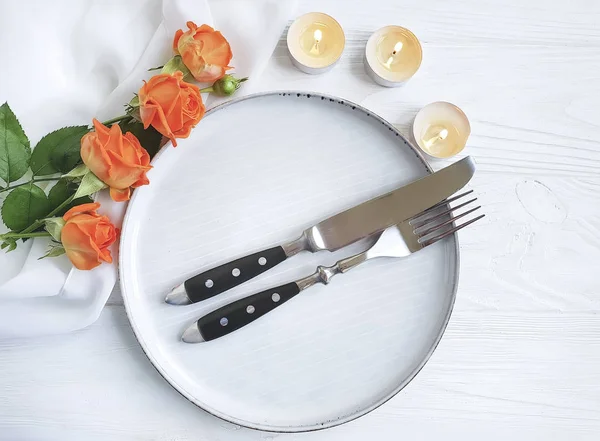 Gül çiçek plaka, ahşap arka plan üzerinde mum