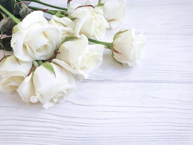 Beyaz ahşap zemin üzerinde beyaz gül buketi