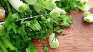 Ahşap tahta yavaş hareket üzerine yeşil soğan bıçağı