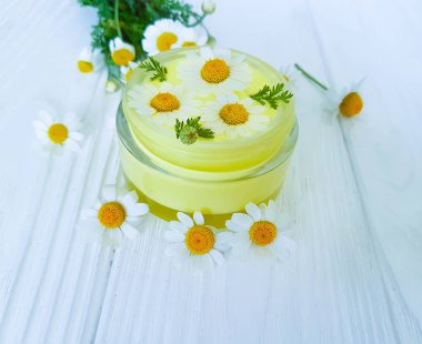 papatya çiçeği, ahşap arka planda kozmetik krem