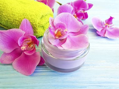 ahşap arka planda krem kozmetik orkide çiçek