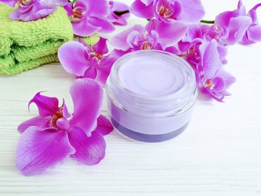 ahşap arka planda krem kozmetik orkide çiçek