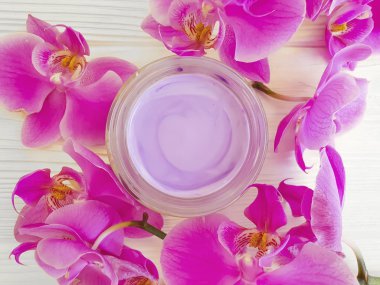 ahşap arka planda krem kozmetik orkide çiçek