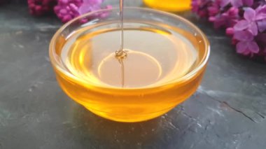 siyah beton arka plan üzerinde bal damlayan leylak çiçek, yavaş hareket