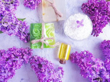 kozmetik yağ, gri beton arka plan üzerinde sabun çiçeği leylak