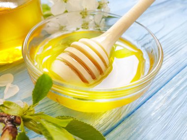fresh honey, blooming cherry on a blue wooden background
