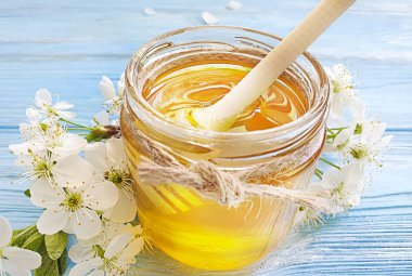 fresh honey, blooming cherry on a blue wooden background
