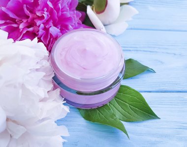 kozmetik krem, mavi ahşap arka plan üzerinde şakayık çiçek