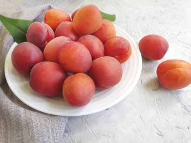 gri beton arka plan üzerinde bir tabak üzerinde taze şeftali