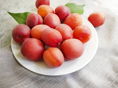 gri beton arka plan üzerinde bir tabak üzerinde taze şeftali