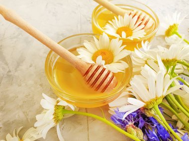 fresh honey, chamomile flower, on gray concrete background