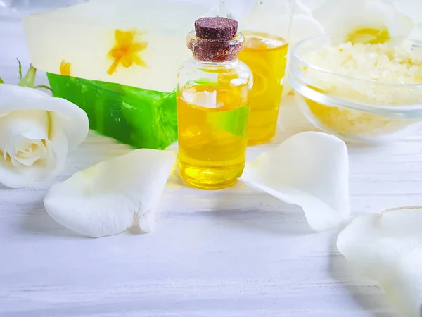 salt, oil, cosmetic cream, soap, rose flower on a wooden background