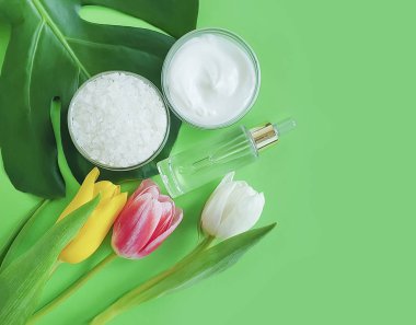 krem kozmetik lale, renkli bir arka plan üzerinde monstera