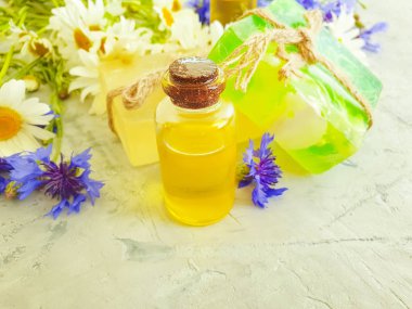 yağ, papatya çiçeği sabun, gri beton arka plan üzerinde cornflower