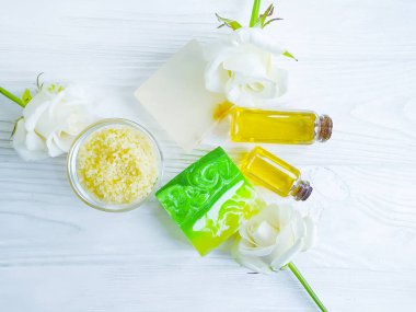 beyaz ahşap arka plan üzerinde yağ, sabun, gül çiçeği