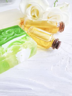 beyaz ahşap arka plan üzerinde yağ, sabun, gül çiçeği
