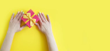  kadın eller renkli bir arka planda bir hediye kutusu tutun