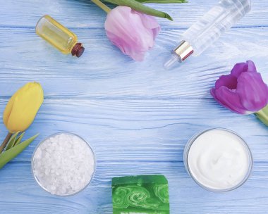ahşap arka planda kozmetik krem, sabun, tuz, lale çiçeği