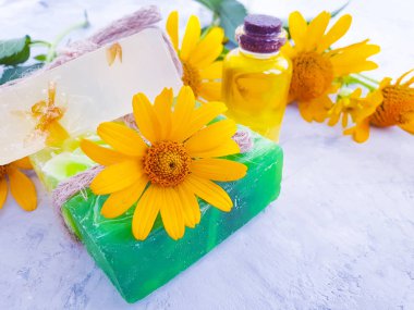 sabun, gri beton arka plan üzerinde calendula çiçek yağı