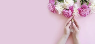 renkli bir arka plan üzerinde kadın elleri çiçek şakayık krem kozmetik