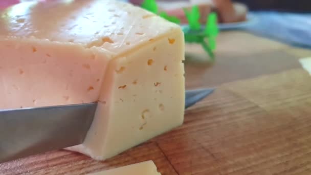 Schnittkäse Mit Einem Messer Auf Einem Hölzernen Hintergrund Zeitlupe — Stockvideo