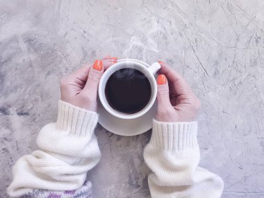 bir kazak kadın elleri beton arka plan üzerinde kahve bir fincan tutun
