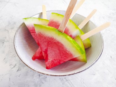 Taze karpuz dilimleri gri beton arka planda bir tabakta