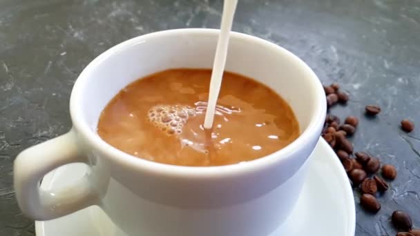 具体的な背景に牛乳を注ぐコーヒーカップ — ストック動画