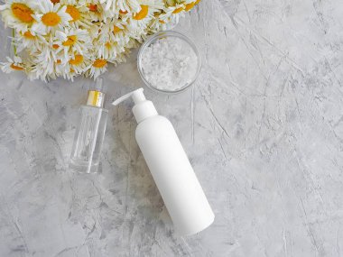 gri beton arka planda krem kozmetik papatya çiçeği