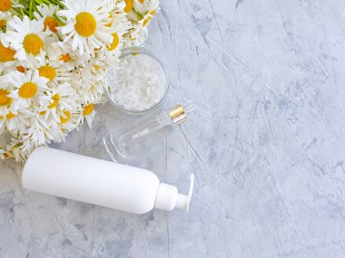 gri beton arka planda krem kozmetik papatya çiçeği