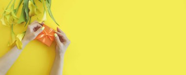 Kadın eli hediye kutusu renkli bir arka planda kalla çiçeği