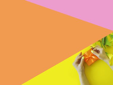 Kadın eli hediye kutusu renkli bir arka planda kalla çiçeği