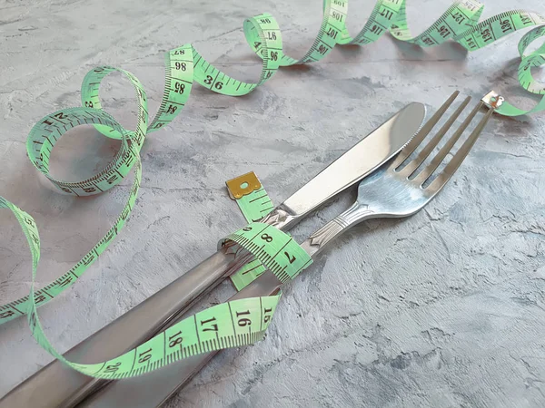 fork knife centimeter tape on concrete background