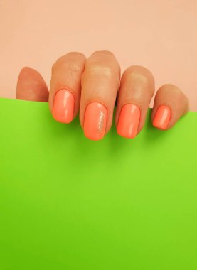 Renkli bir arka planda kadın eli manikürü.