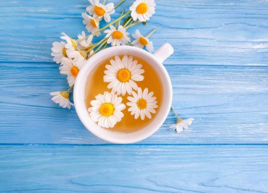 Ahşap zemin üzerinde papatya çiçeği çayı