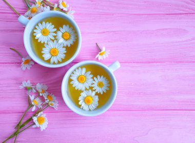 Ahşap zemin üzerinde papatya çiçeği çayı