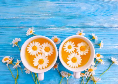 Ahşap zemin üzerinde papatya çiçeği çayı