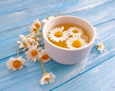 Ahşap zemin üzerinde papatya çiçeği çayı