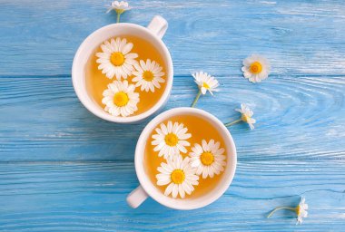 Ahşap zemin üzerinde papatya çiçeği çayı
