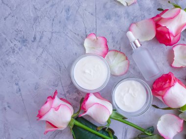 Beton zemin üzerinde krem kozmetik gül çiçeği