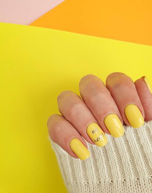  Kadın eli. Renkli arka planda güzel bir manikür stili.