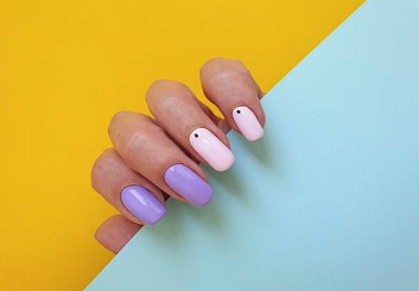 Kadın eli. Renkli arka planda güzel bir manikür.