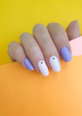 Kadın eli. Renkli bir arka planda şık bir manikür.