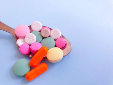 Renkli arka planda kaşık hapları vitaminleri