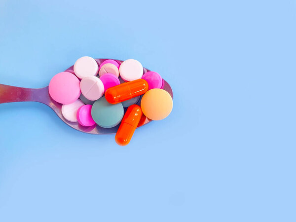 colored pills vitamins spoon background