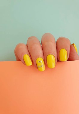 Kadın eli. Renkli arka planda güzel manikür.