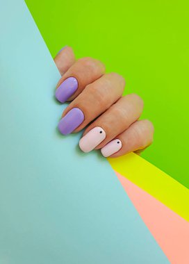 Kadın eli. Renkli arka planda güzel bir manikür.