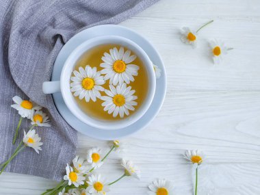 Ahşap zemin üzerinde papatya çiçeği çayı